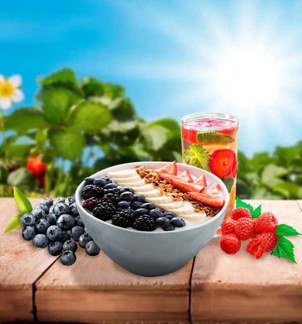 A fresh fruit bowl filled with vibrant fruits like oranges, bananas, and berries, arranged in a rustic bowl on a wooden surface