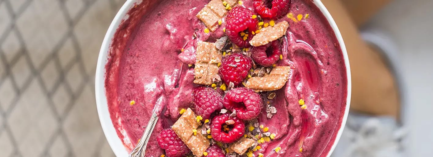 Raspberry smoothie bowl topped with fresh fruit and granola – a vibrant and healthy breakfast option