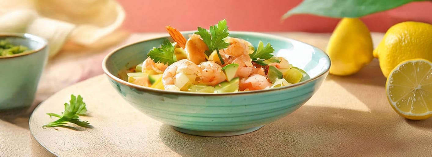 Shrimp Ceviche_header Shrimp ceviche with fresh avocado, cucumber, red onion, and citrus marinade, garnished with cilantro.